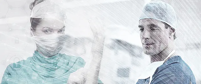 verschwommenes Bild von zwei Chirurgen in OP Schutzkleidung