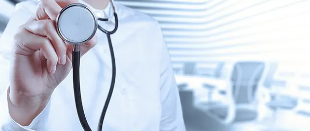 Foto zeigt eine Ärztin, mit Fokus auf dem Stethoskop