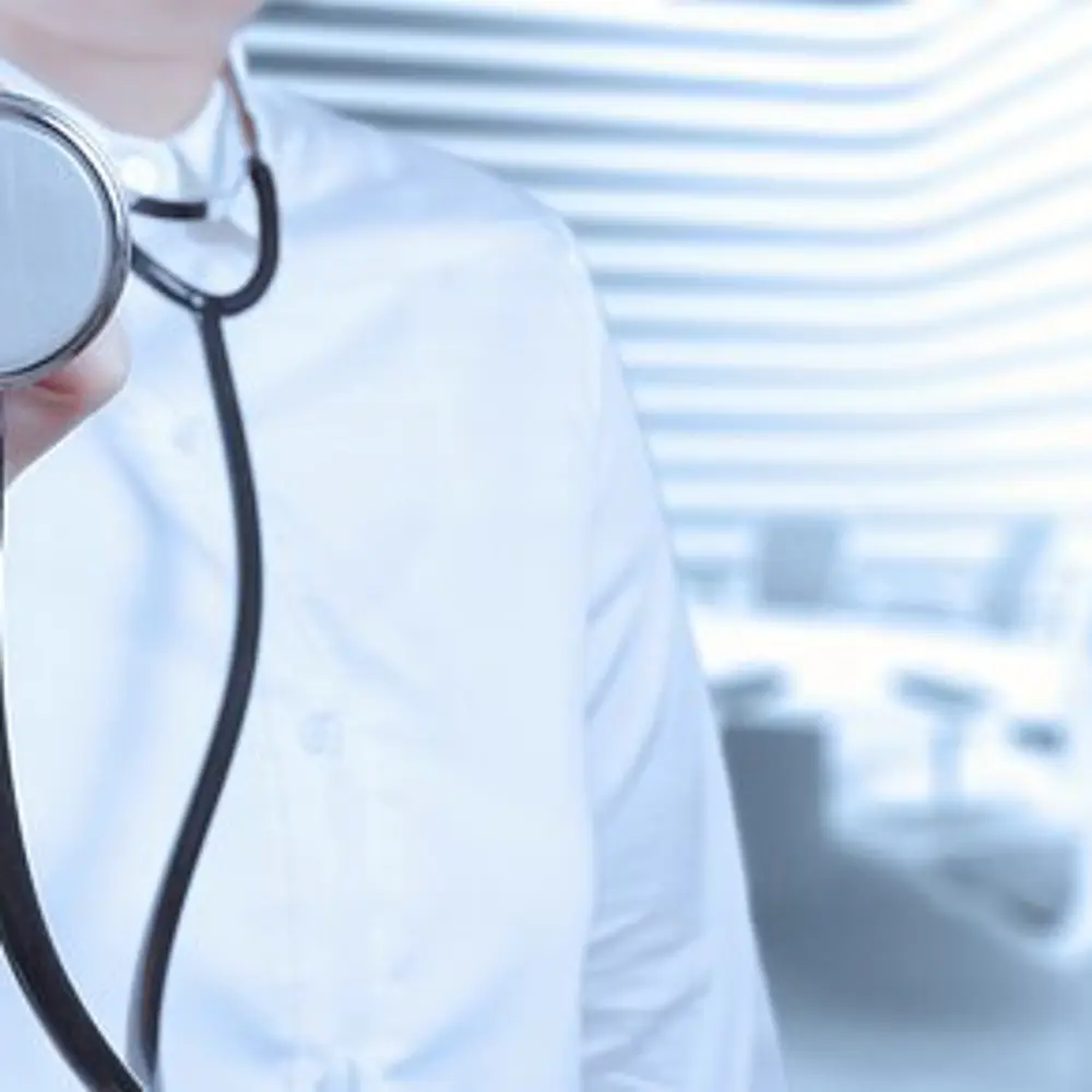 Foto zeigt eine Ärztin, mit Fokus auf dem Stethoskop