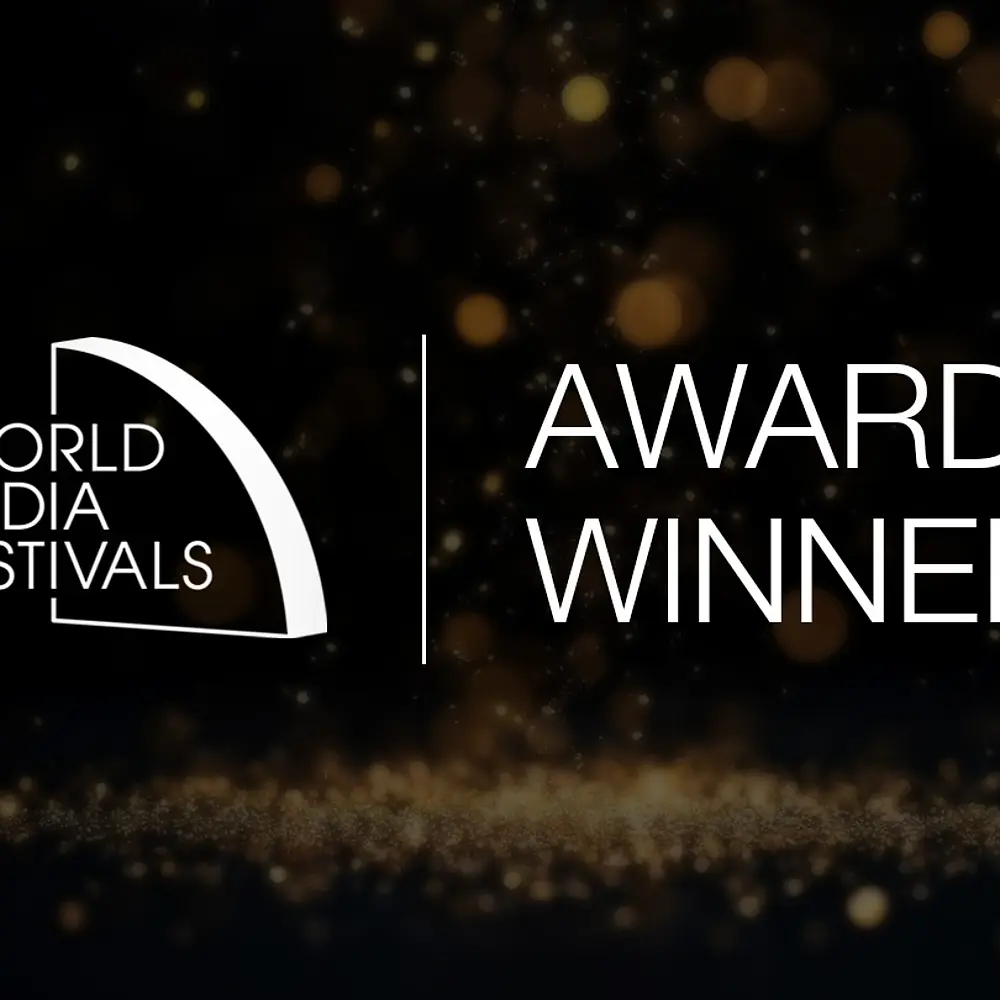 Gewinner-Visual des World Media Festivals mit Logo und Schriftzug "Award Winner" auf dunklem Hintergrund mit goldenen Lichtern