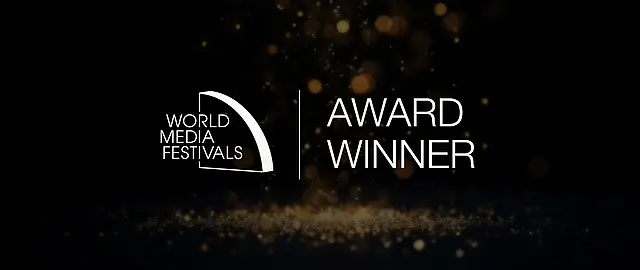 Gewinner-Visual des World Media Festivals mit Logo und Schriftzug "Award Winner" auf dunklem Hintergrund mit goldenen Lichtern