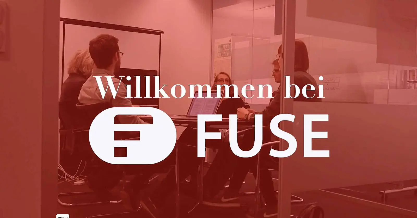 Ein rot getöntes Bild zeigt mehrere Personen in einem Besprechungsraum bei einem Meeting. Darüber liegen der Schriftzug „Willkommen bei“ sowie das FUSE-Logo und der Name FUSE in Weiß.
