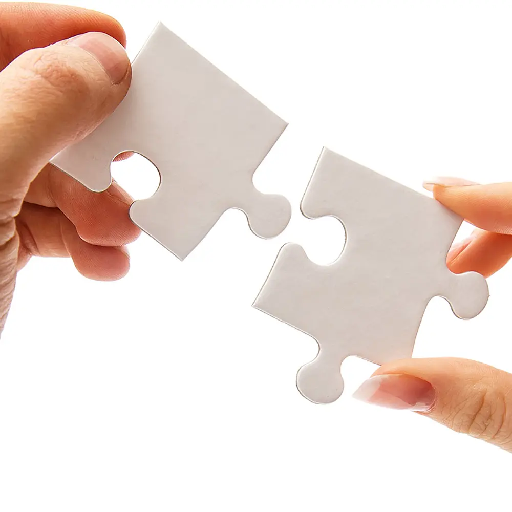 Zwei Hände halten jeweils ein Puzzleteil die zusammenpassen