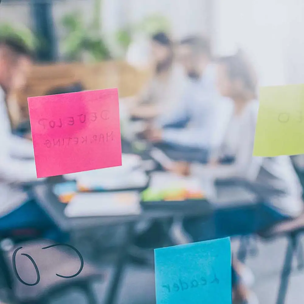 Foto mit Menschen am Tisch, die gemeinsam Brainstorming betreiben