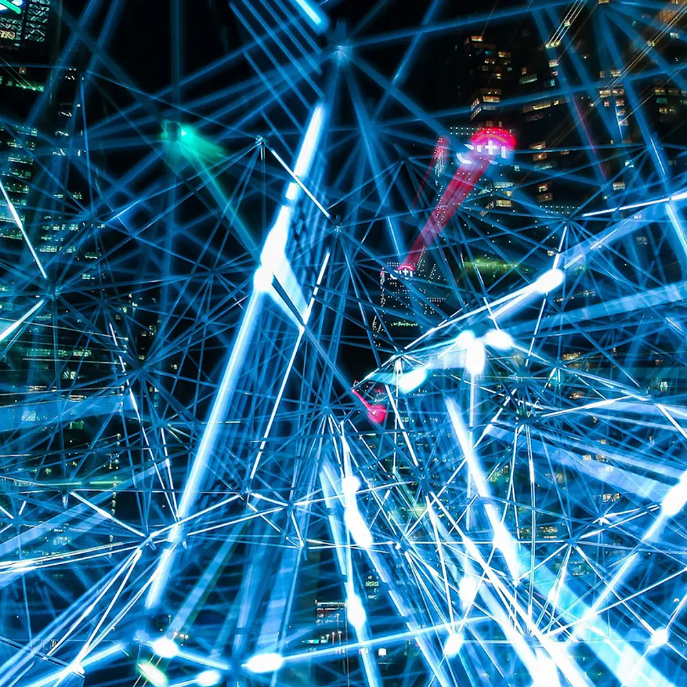 blaues Netz aus Lichtern mit modernen Hochhäusern im Hintergrund