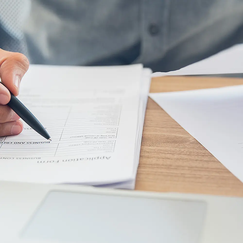 Foto von einem Vertrag, der gerade ausgefüllt wird