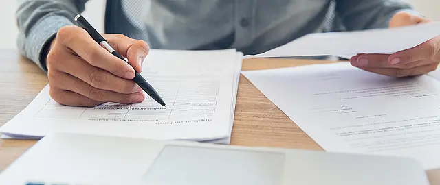 Foto von einem Vertrag, der gerade ausgefüllt wird