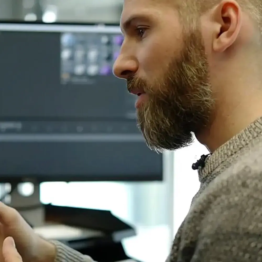 Foto: Mann mit Vollbart erklärt etwas an seinem Arbeitsplatz