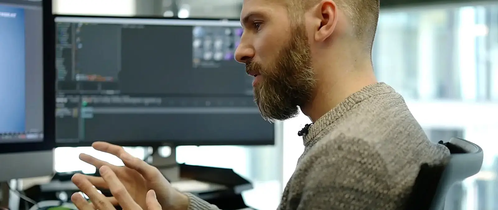 Foto: Mann mit Vollbart erklärt etwas an seinem Arbeitsplatz