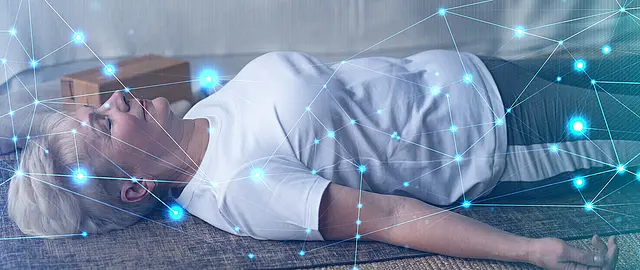 Foto einer älteren Frau in Sportkleidung, die entspannt und mit geschlossenen Augen auf dem Rücken auf einer Matte liegt