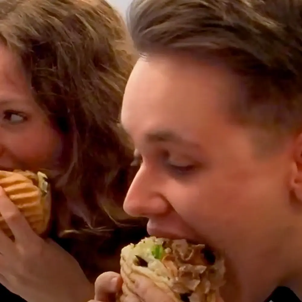 Foto, wie Philipp Renken und Rikea Harms einen Döner am Arbeitsplatz essen