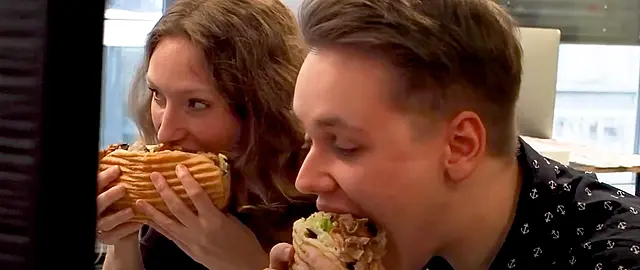 Foto, wie Philipp Renken und Rikea Harms einen Döner am Arbeitsplatz essen