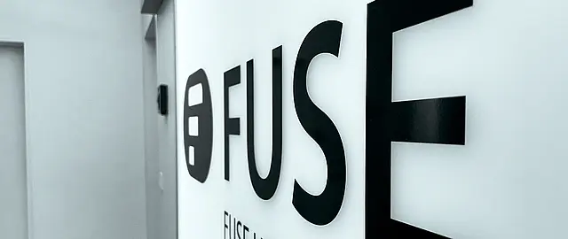 Foto vom Firmennamen und Logo vor der Agentur