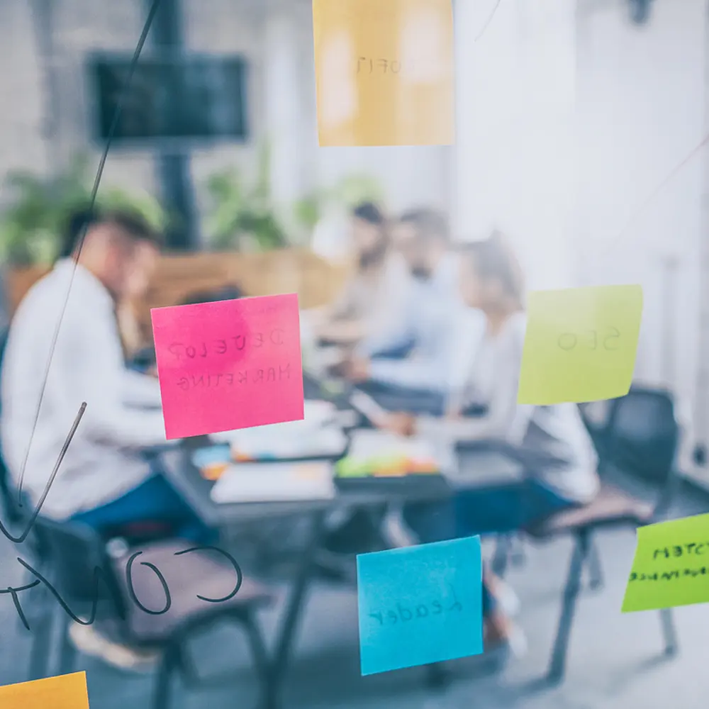 Durch einen Glasscheibe hindurch fotografierte Brainstorming- Szene