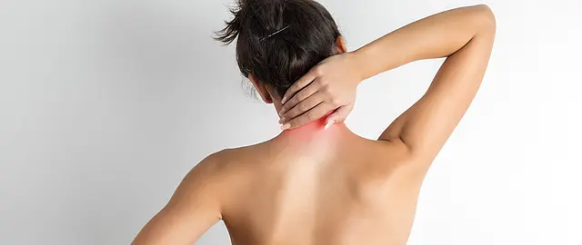 Frau von hinten mit chronischen Rückenschmerzen