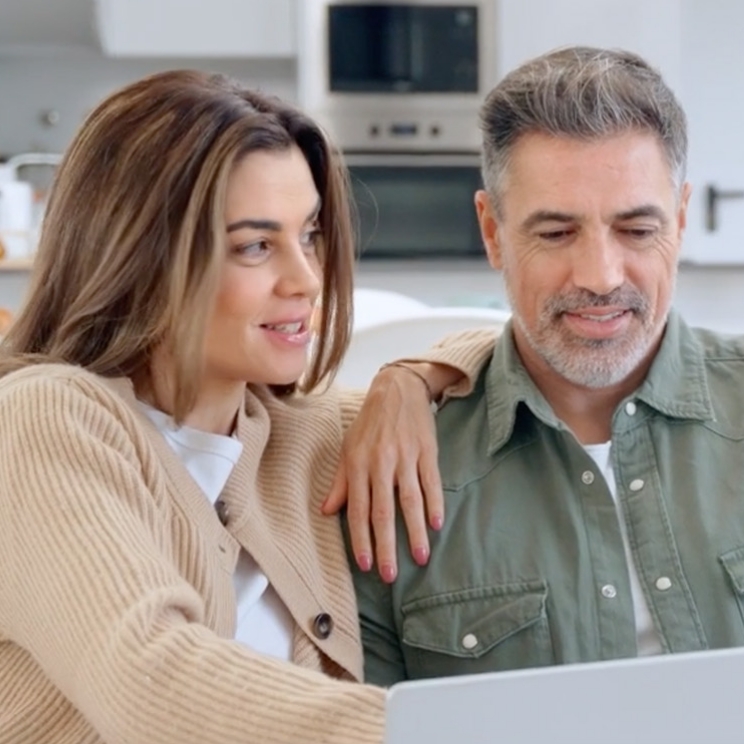 Frau und Mann sitzen nah beieinander und schauen auf einen Laptop
