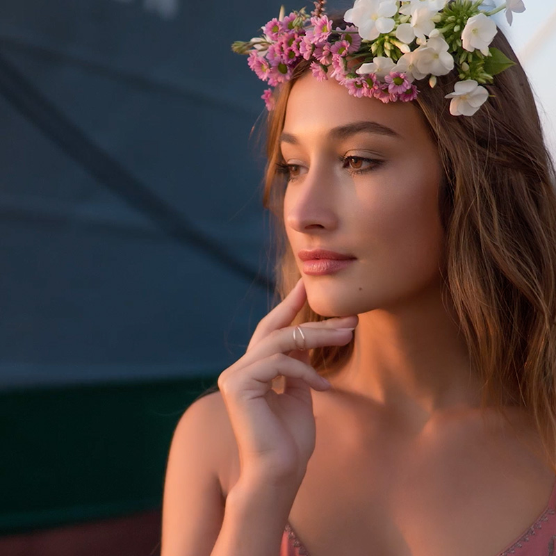Junge Frau mit Blumenkranz im warmen Licht für Olympus Produktfilm