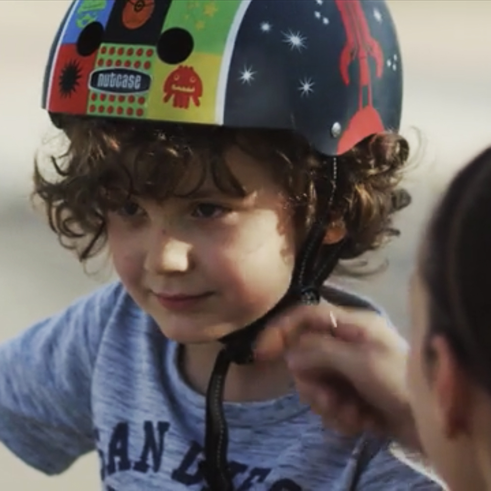 Kind mit Fahrradhelm beim Anlegen des Kinnriemens für Imagefilm