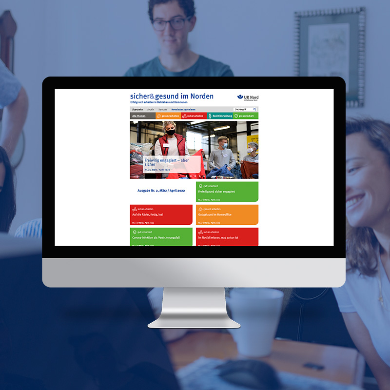 Website „sicher & gesund im Norden“ auf einem Desktop-Monitor vor unscharfem Hintergrund mit Menschen im Gespräch.